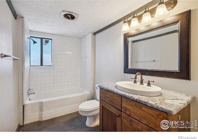 full bathroom with tiled shower / bath combo, toilet, vanity, tile patterned floors, and a textured ceiling