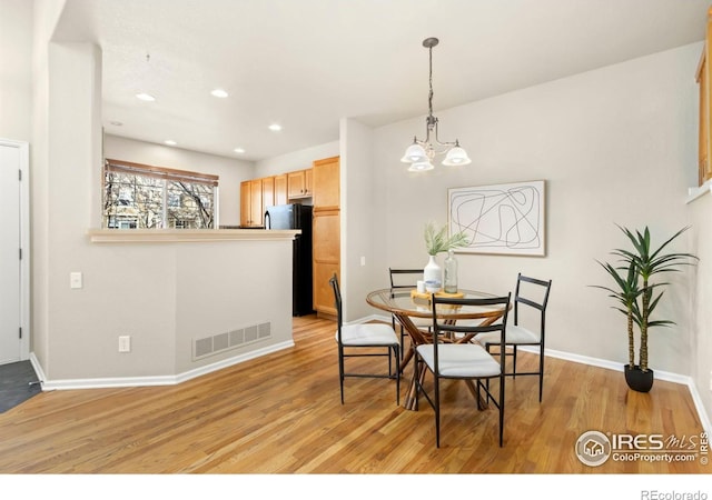 dining room featuring an inviting chandelier and light wood-type flooring