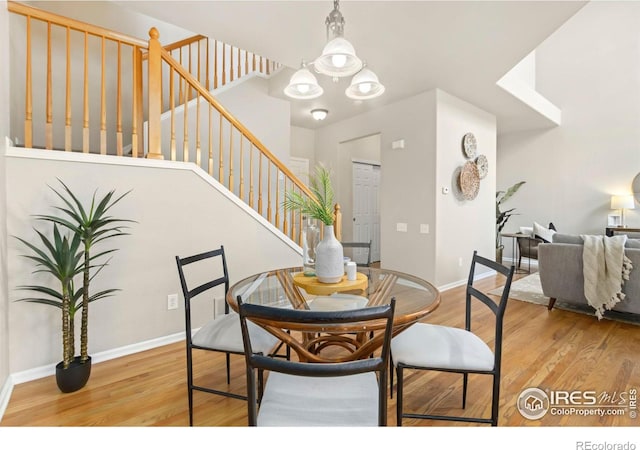 dining space with an inviting chandelier and light hardwood / wood-style floors