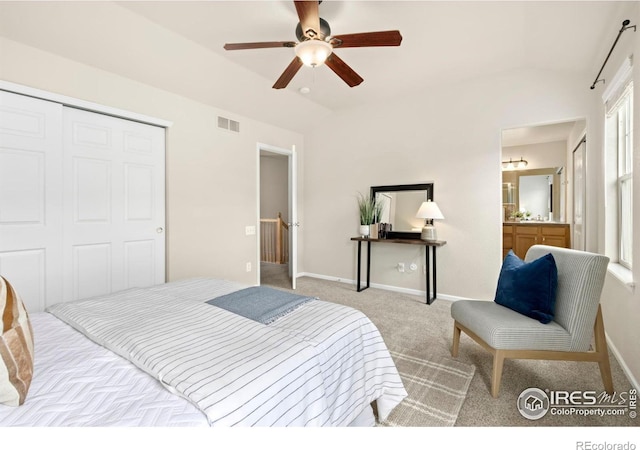 bedroom featuring lofted ceiling, light carpet, ceiling fan, connected bathroom, and a closet