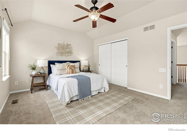 bedroom with lofted ceiling, a closet, ceiling fan, and carpet floors