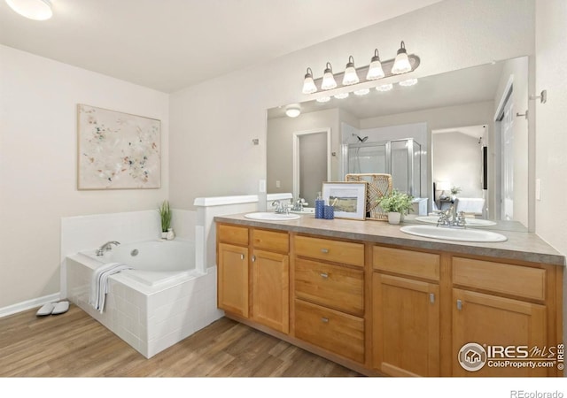 bathroom featuring plus walk in shower, vanity, and hardwood / wood-style flooring