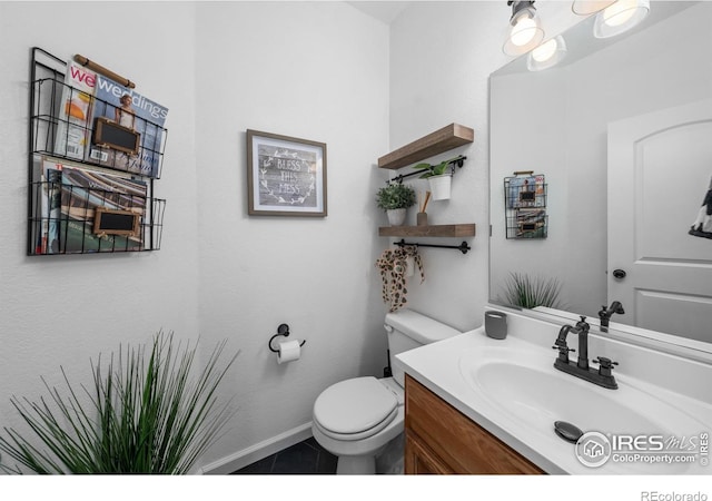 bathroom with tile patterned flooring, vanity, and toilet