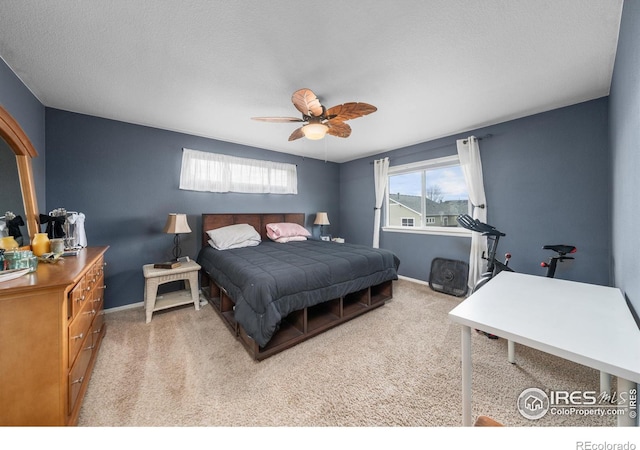 carpeted bedroom with ceiling fan and a textured ceiling