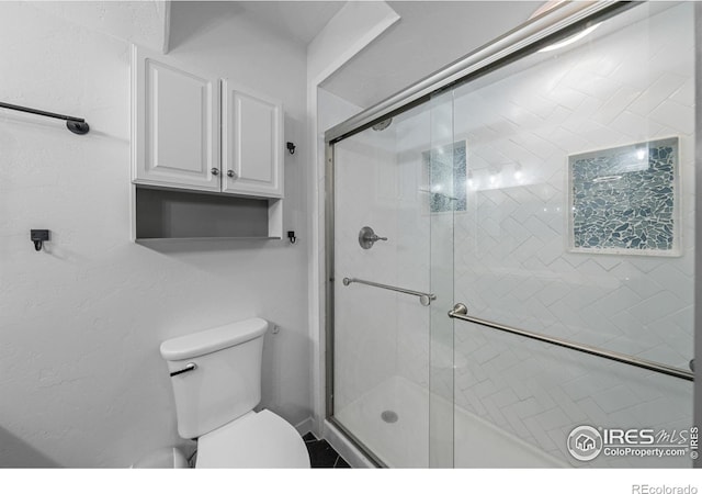 bathroom with an enclosed shower and toilet