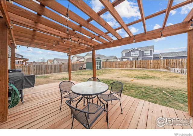 wooden deck with a yard, a pergola, and a storage shed