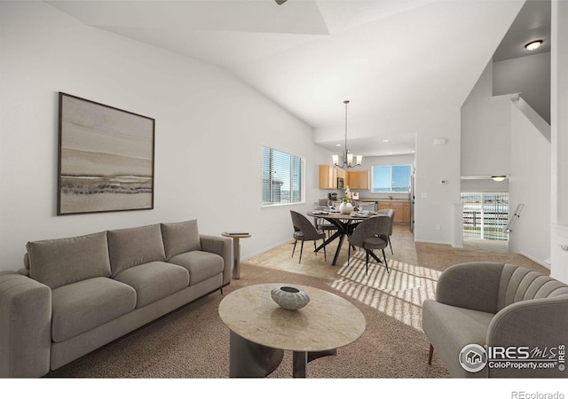 living room featuring lofted ceiling, light carpet, and a chandelier