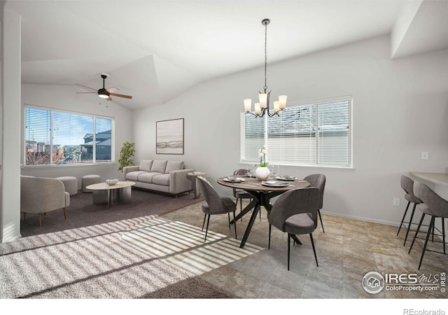 dining room featuring ceiling fan with notable chandelier and lofted ceiling