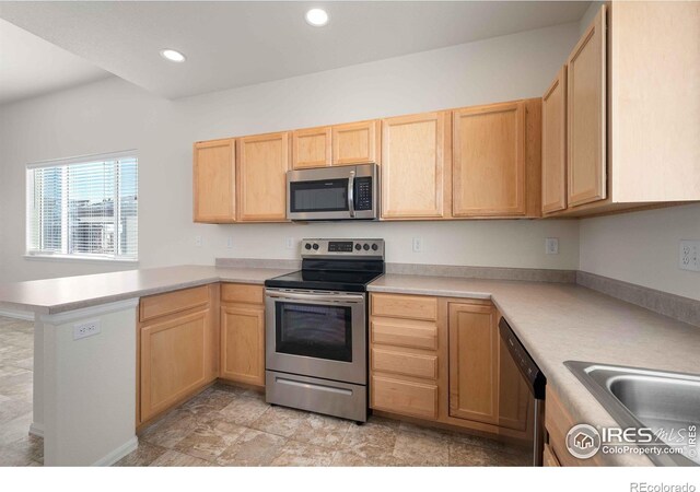 kitchen with kitchen peninsula, stainless steel appliances, and light brown cabinetry