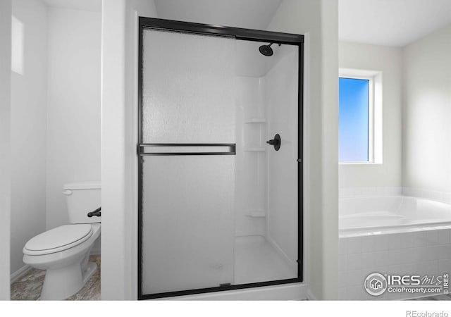 bathroom with toilet and shower with separate bathtub