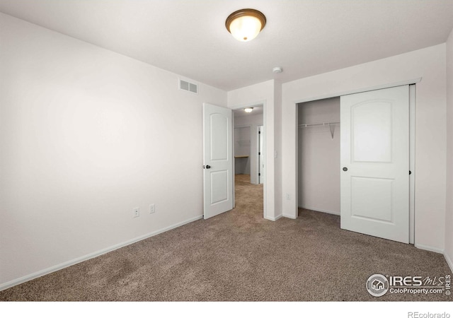 unfurnished bedroom with carpet flooring and a closet