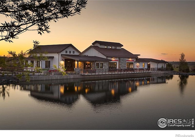 back house at dusk featuring a water view