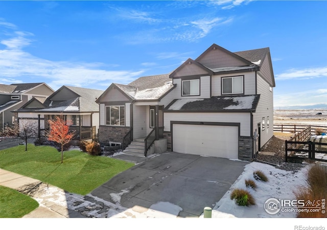 view of front of property featuring a garage, driveway, stone siding, fence, and a front lawn