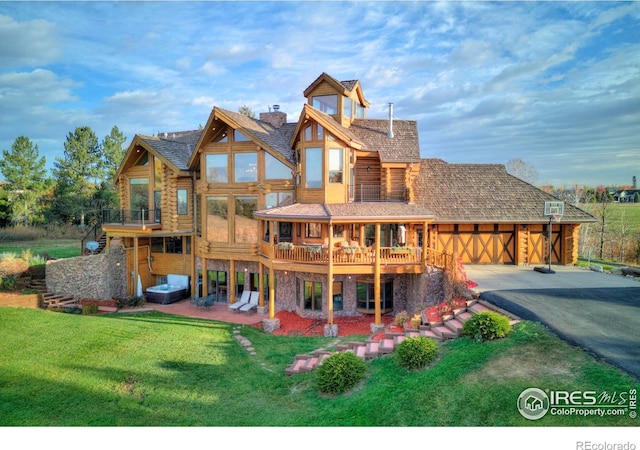 rear view of property with a balcony, a yard, and a patio area