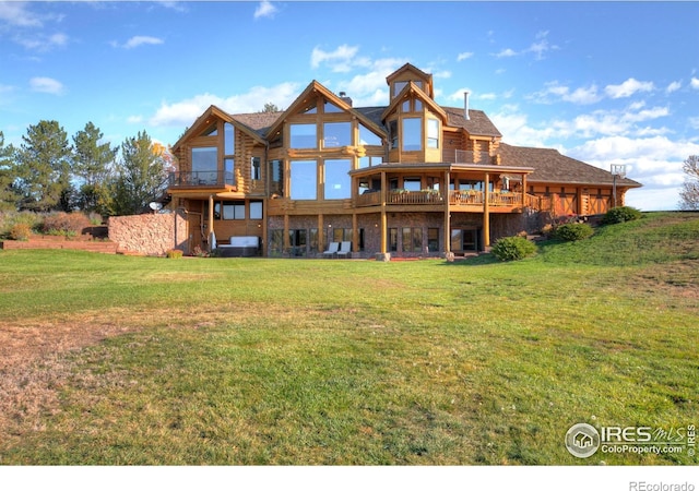 rear view of property with a deck and a yard