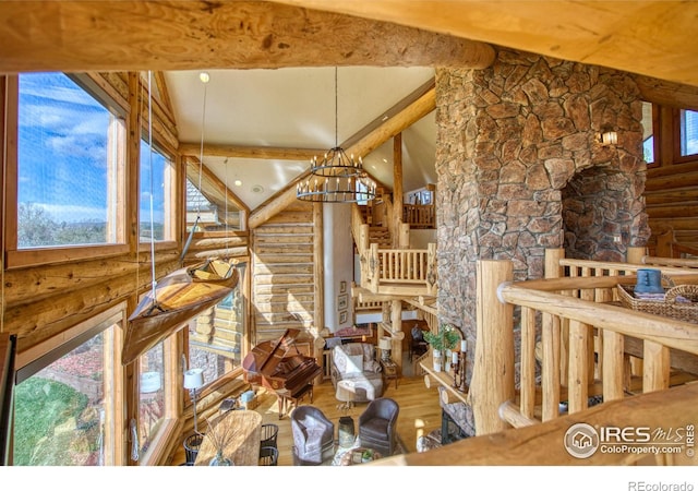 misc room featuring a chandelier, log walls, and vaulted ceiling with beams