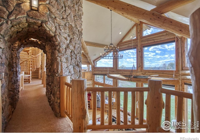 corridor featuring high vaulted ceiling, light carpet, a notable chandelier, and beam ceiling