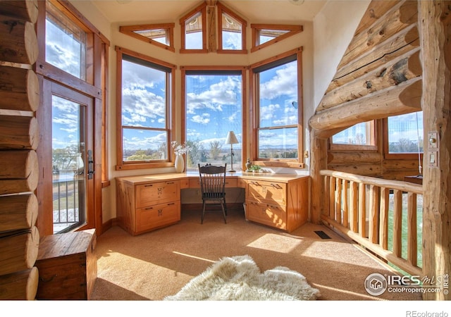 home office featuring rustic walls, vaulted ceiling, and light colored carpet