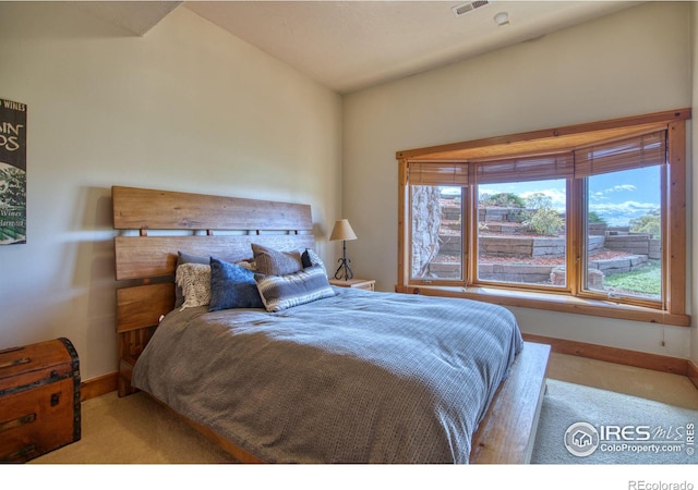 bedroom featuring lofted ceiling and light colored carpet