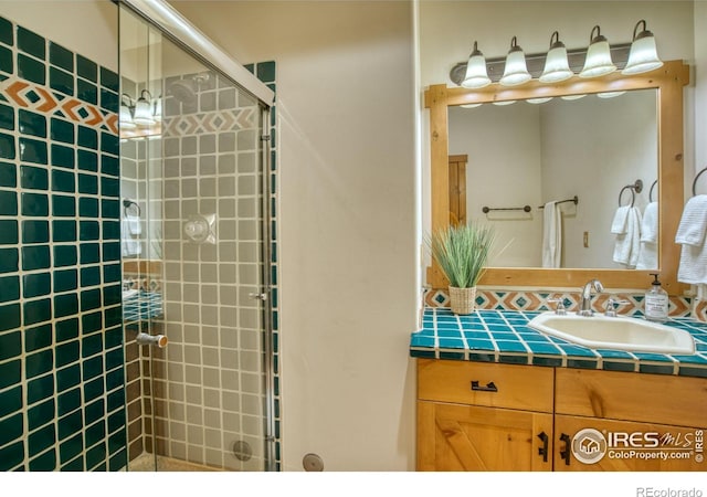 bathroom with a shower with door and vanity