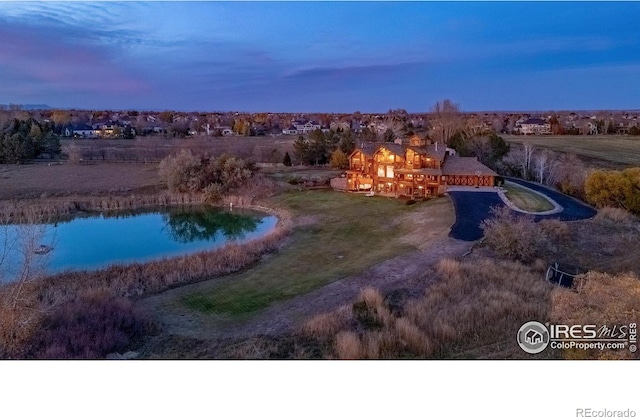 aerial view at dusk with a rural view and a water view