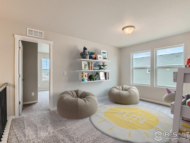 sitting room featuring plenty of natural light and carpet flooring