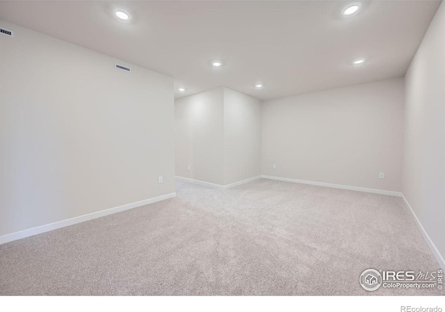 unfurnished room featuring light carpet