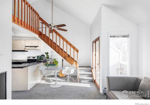 entryway featuring ceiling fan, light colored carpet, high vaulted ceiling, and a baseboard heating unit