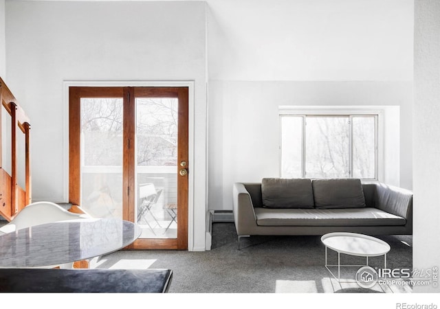 carpeted living room with a baseboard heating unit