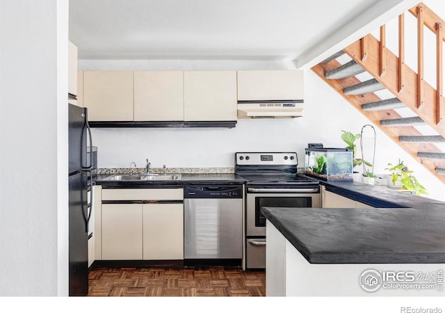 kitchen with dark parquet flooring, stainless steel appliances, sink, and kitchen peninsula