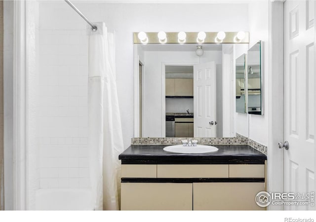 bathroom with vanity, tasteful backsplash, and shower / bath combo with shower curtain