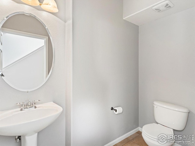 bathroom featuring toilet, tile patterned flooring, and sink