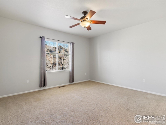 carpeted spare room featuring ceiling fan