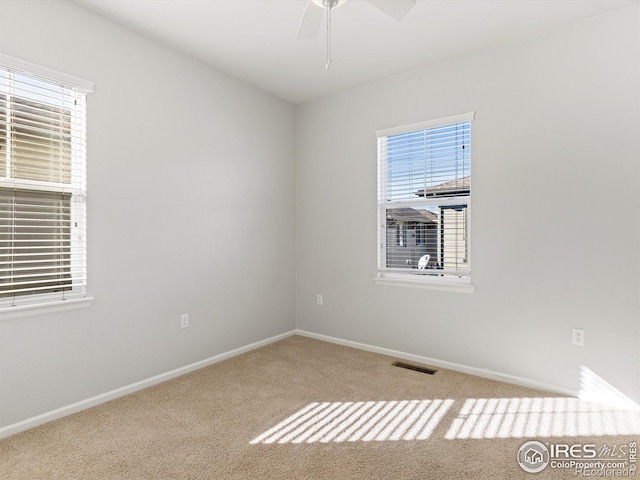 carpeted spare room with ceiling fan