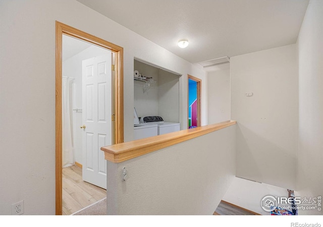 hallway with washer and clothes dryer and light hardwood / wood-style floors