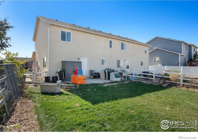 rear view of house featuring a yard and a patio area