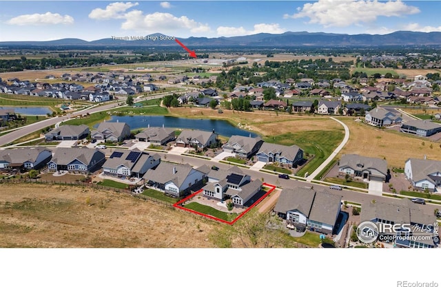 drone / aerial view with a water and mountain view