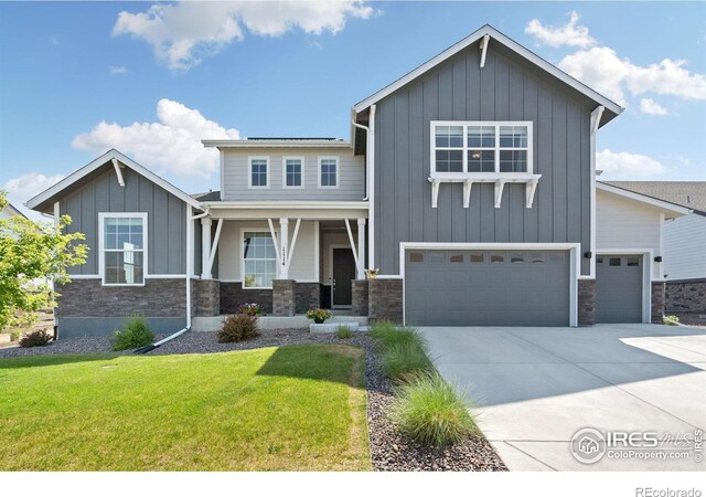 view of front of property with a garage, covered porch, and a front yard