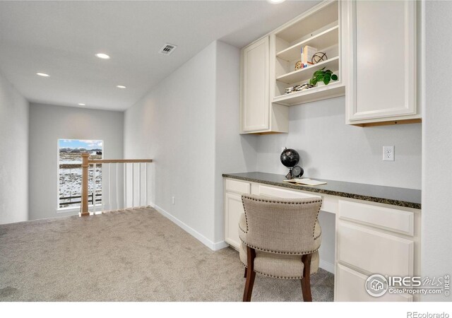 carpeted home office with built in desk