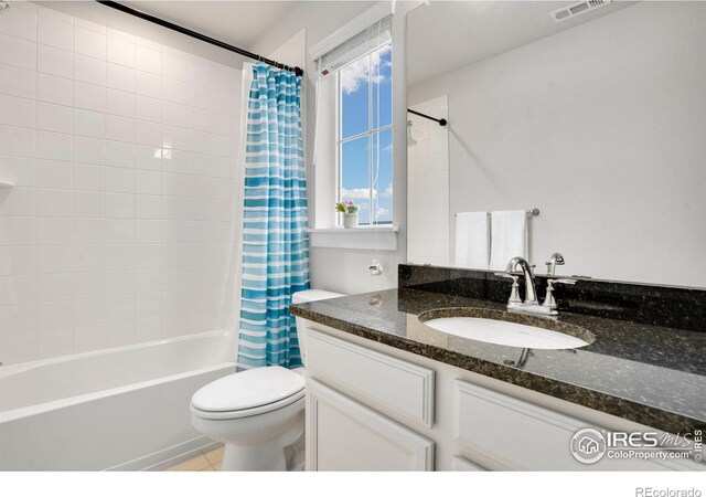 full bathroom featuring vanity, tile patterned flooring, toilet, and shower / bath combo with shower curtain