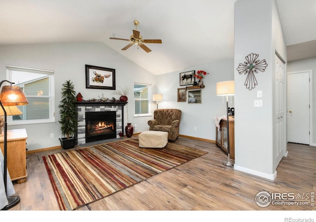 living room featuring lofted ceiling, a fireplace, ceiling fan, and hardwood / wood-style flooring