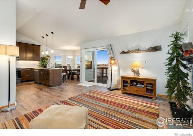 living room with lofted ceiling, ceiling fan, hardwood / wood-style floors, and sink