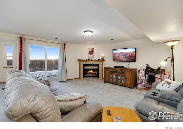 carpeted living room with a tiled fireplace