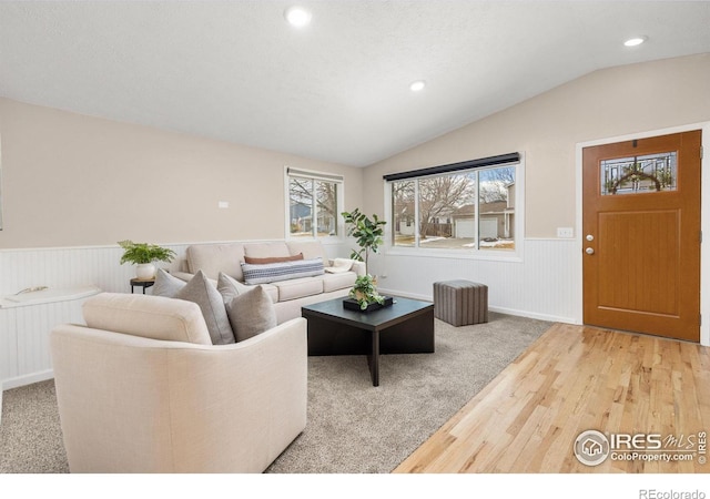 living room featuring a textured ceiling, lofted ceiling, and wood-type flooring