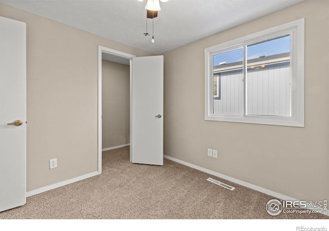 unfurnished bedroom featuring ceiling fan and light colored carpet