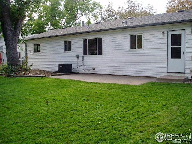 rear view of property with a patio, central AC, and a lawn