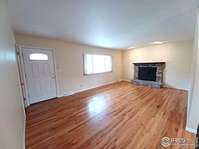 unfurnished living room with a fireplace and light hardwood / wood-style floors