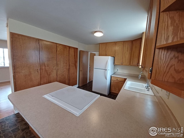 kitchen with sink, white appliances, and kitchen peninsula