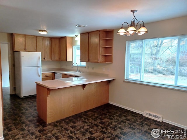 kitchen with white appliances, hanging light fixtures, kitchen peninsula, a notable chandelier, and sink