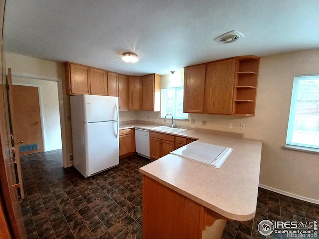 kitchen with white appliances, sink, and kitchen peninsula